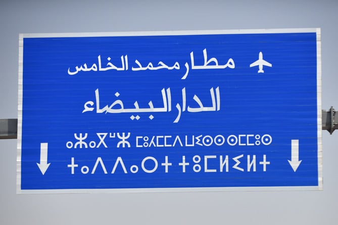 road sign with two alphabets—Arabic, and Tifinagh, used to write the Berber language